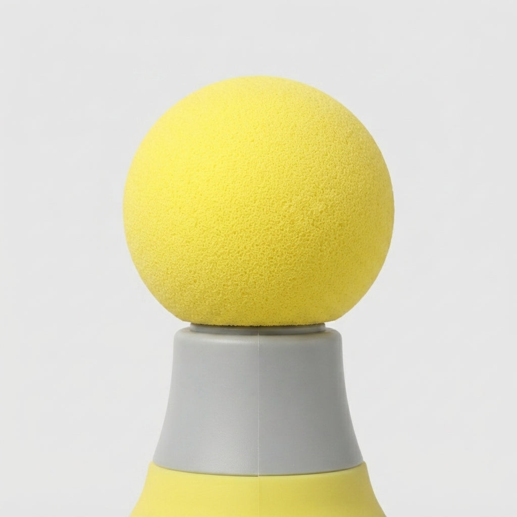 A close-up of a yellow textured spherical object resting on a gray and yellow conical base against a light gray background.